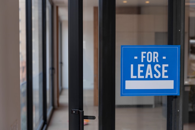 Glass door with a blue For Lease sign on it