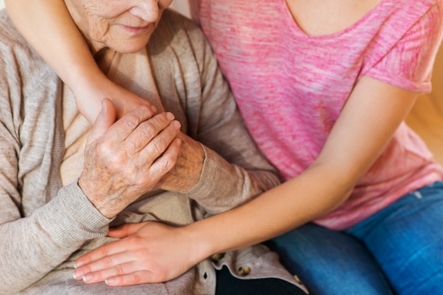 unrecognizable grandmother and her granddaughter holding hands