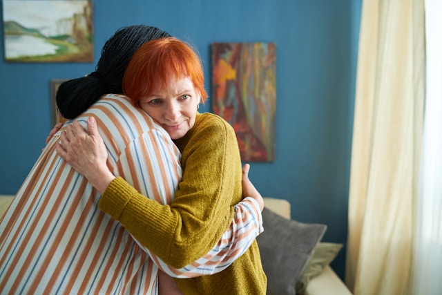 Mother and daughter hugging, you can only see the mother's face